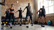 © Svitlana - Fast. Hard. Again. Group of sportive people jumping, warming up before having workout with dumbbells at industrial gym. Group training concept