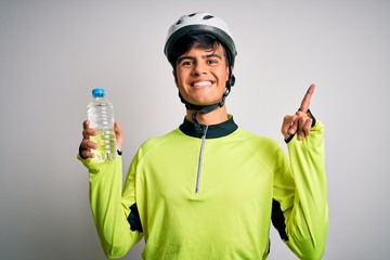 Poster - Young handsome cyclist man wearing security bike helmet drinking bottle of water surprised with an idea or question pointing finger with happy face, number one