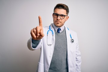 Wall Mural - Young doctor man with blue eyes wearing medical coat and stethoscope over isolated background Pointing with finger up and angry expression, showing no gesture