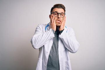 Wall Mural - Young doctor man with blue eyes wearing medical coat and stethoscope over isolated background Tired hands covering face, depression and sadness, upset and irritated for problem