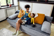 © Svitlana - Winners. African american woman, baby sitter and caucasian cute little girl having fun together, playing video games, sitting on the couch. Children education, leisure activities, babysitting concept