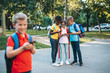 © hedgehog94 - Group of happy elementary school students with smartphones. Primary education, friendship, childhood, and technology concept.