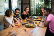 © Anna Kosolapova - A multi-ethnic group of friends having a good time in a cafe