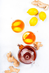 Sticker - Healing black herbal tea with ginger, honey, lemon and mint. Immune booster drink in glass cup on white kitchen table background with copy space. Top view