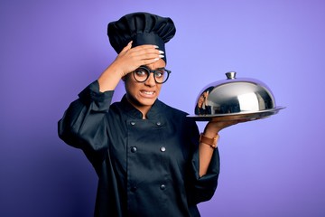 Canvas Print - Young african american cooker girl wearing uniform and hat holding tray with dome stressed with hand on head, shocked with shame and surprise face, angry and frustrated. Fear and upset for mistake.