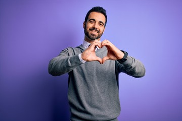 Sticker - Handsome businessman with beard wearing casual tie standing over purple background smiling in love doing heart symbol shape with hands. Romantic concept.