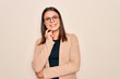 © Krakenimages.com - Young beautiful brunette businesswoman wearing jacket and glasses over white background looking confident at the camera with smile with crossed arms and hand raised on chin. Thinking positive.
