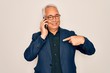 © Krakenimages.com - Middle age senior grey-haired business man wearing glasses talking on smartphone with surprise face pointing finger to himself