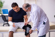 © Elnur - Young injured man visiting experienced male doctor traumatologis
