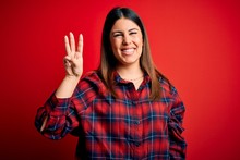 Young Beautiful Woman Wearing Casual Shirt Over Red Background Showing And Pointing Up With Fingers Number Three While Smiling Confident And Happy.