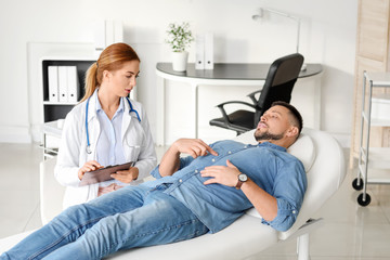 Gastroenterologist examining man in clinic