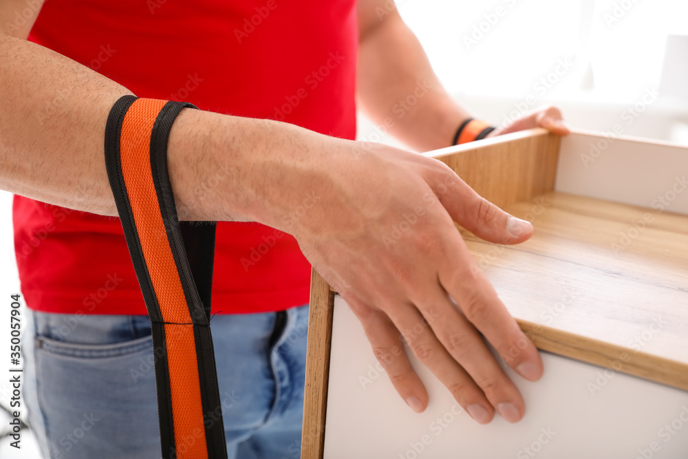 Loader carrying furniture by using cargo belts, closeup