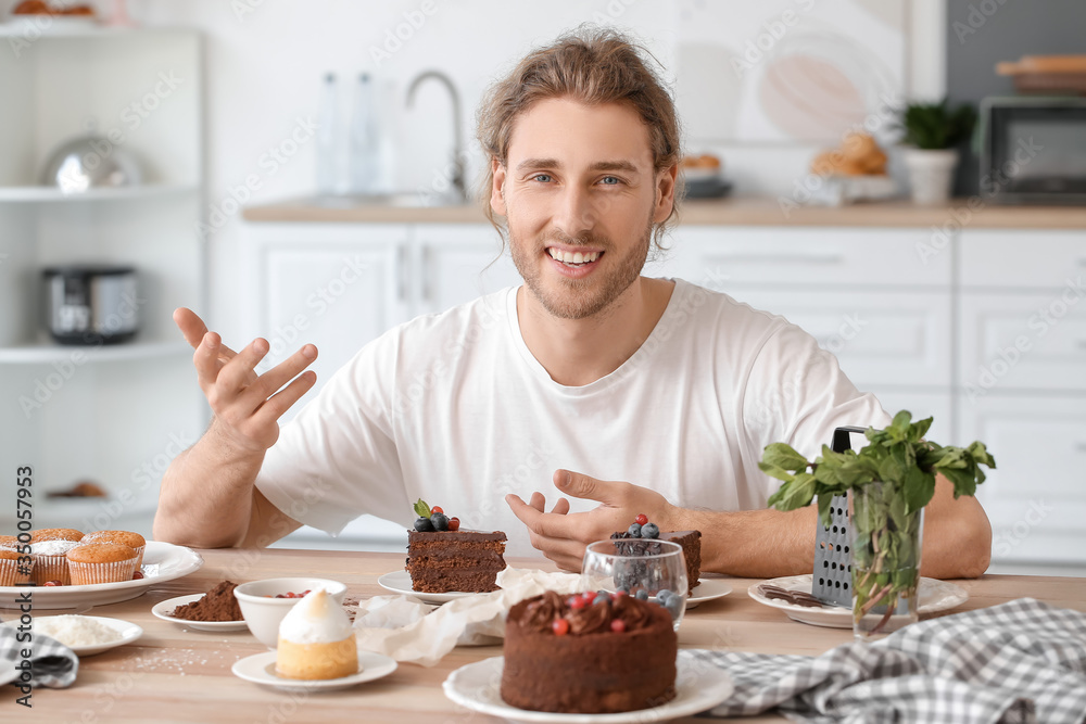 Male confectioner with tasty desserts in kitchen