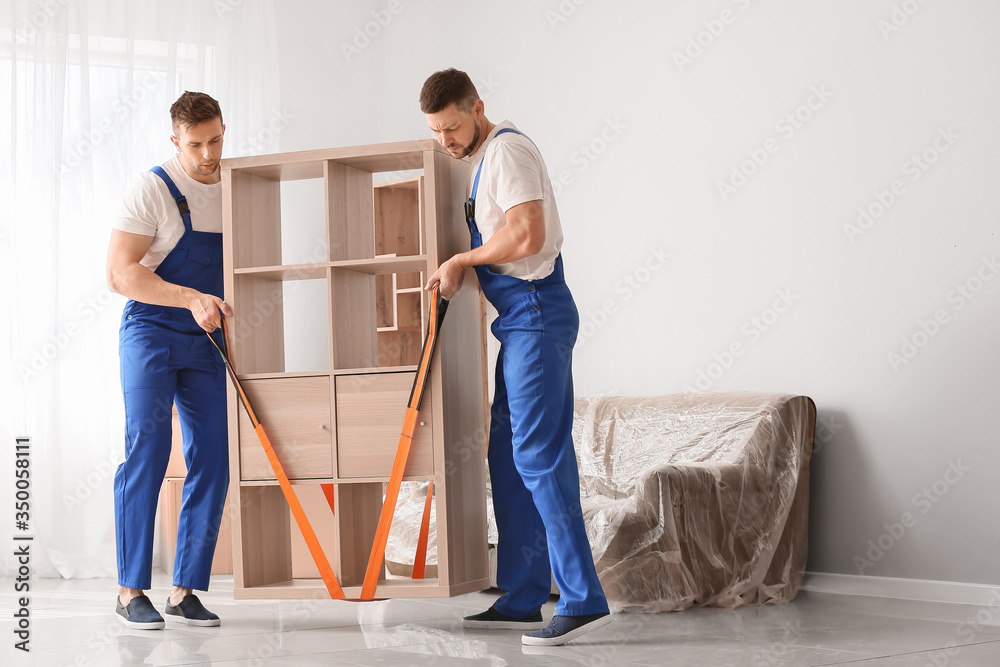 Loaders carrying furniture in flat