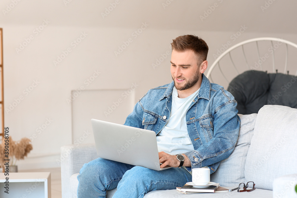 Young man with laptop working at home