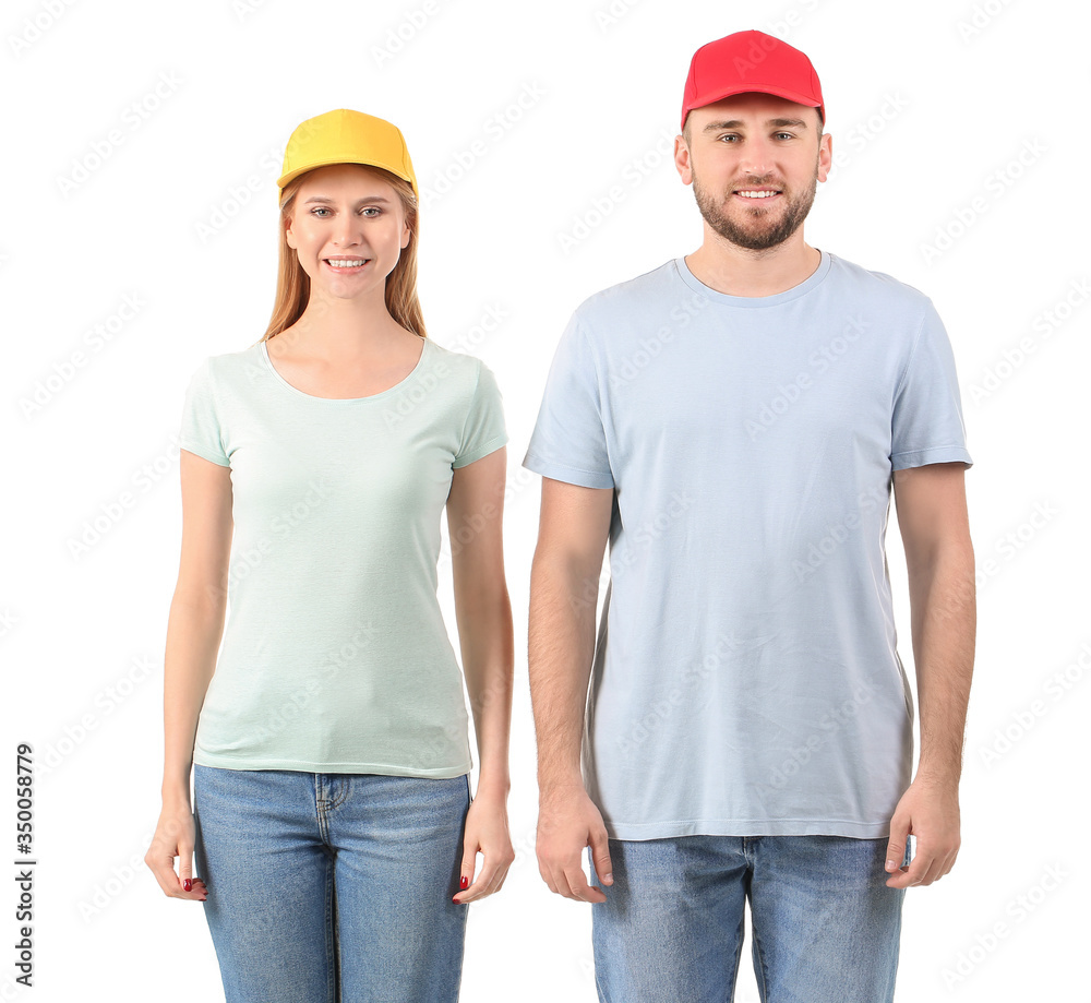 Young couple in stylish caps on white background