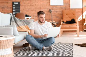 Canvas Print - Young man with laptop working at home