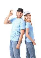 Wall Mural - Young couple in stylish caps showing OK gesture on white background