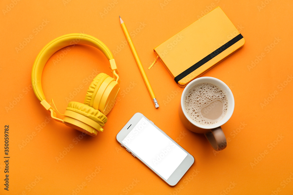 Modern mobile phone with headphones, notebook, cup of coffee and pencil on color background - obrazy, fototapety, plakaty 