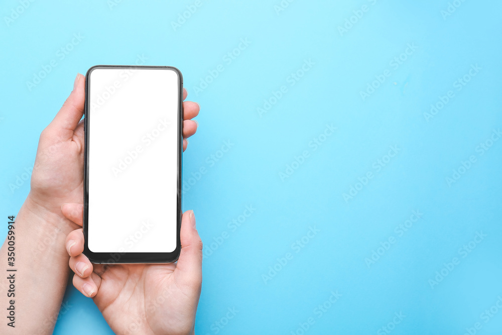 Female hands with mobile phone on color background
