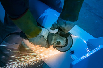 Poster - Machine grinding of a metal part. Finishing of a metal product. Edging machine in the hands of a locksmith. Metal sanding. The removal of the irregularities.