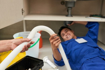 Sticker - Hand of senior woman giving plastic pipe to plumber who is fixing leakage