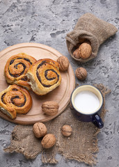 Sticker - Basket of homemade buns with jam, served on old wooden table with walnuts and cup of milk