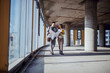 © Dusan Petkovic - Full length of attractive caucasian architects walking in future business center and talking about fresh ideas for building. Man holding blueprints while woman holding paperwork.