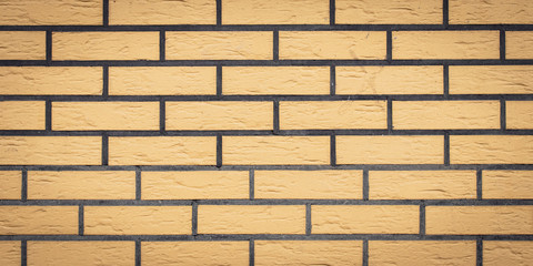 Wall Mural - Brick wall texture, stone background. Yellow bricks pattern. Wide panorama, panoramic banner. Architecture facade, tiled surface, rock frame.