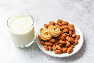 Wall Mural - almond milk glass and cookie for breakfast health food - almonds nuts on white plate background