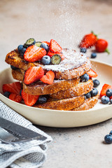 Canvas Print - Traditional French toasts with blueberries, strawberries and powdered sugar on white plate.