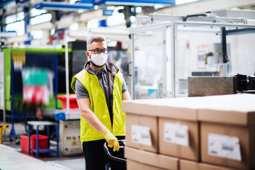 Wall Mural - Man worker with protective mask working in industrial factory or warehouse.