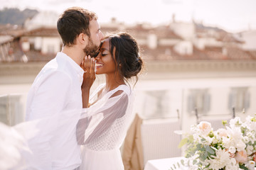 destination fine-art wedding in florence, italy. caucasian groom and african-american bride cuddling