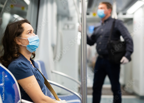 Cuadros en Lienzo Female passenger in personal protective equipment traveling in subway during the