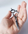 © Stockgurulab - hand holds hairdressing scissors close-up, on a white light background