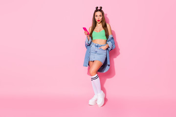 Poster - Full size photo of pretty shocked lady hold telephone texting friends wear denim jacket green crop top naked belly mini shirt knee socks shoes isolated pastel pink color background