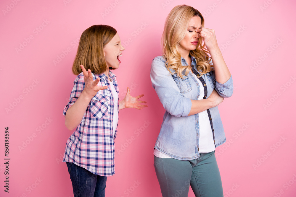 Frustrated two people aggressive kid girl yell scream mother touch nose suffer headache hate family misunderstanding wear denim jeans checkered plaid shirt isolated pastel color background - obrazy, fototapety, plakaty 