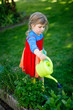 © Irina Schmidt - Beautiful little toddler girl in yellow rubber boots and colorful dress watering spring flowers with kids water can. Happy child helping in family garden, outdoors.