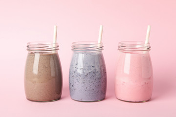 Wall Mural - Blueberry, strawberry and chocolate milkshakes on pink background. Delicious drink