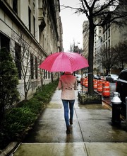 Rear View Of Woman With Pink Umbrella Walking On Sidewalk