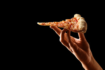 Hand holding slice of cheese pizza cut in slices