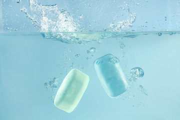 two soap bars getting into water splash, clean concept 