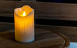 Plastic flameless electronic candle on a wooden background