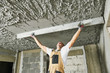 © Kadmy - Plasterer smoothing plaster mortar on ceiling with screeder