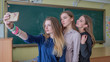 © Довидович Михаил - Beautiful schoolgirls take pictures of themselves in the classroom.