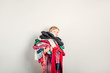 © anoushkatoronto - Mommy little helper. Cute Caucasian girl sorting clothes. Adorable funny child arranging organazing clothing. Kid holding messy stack pile of clothes, things. Home chores housework.
