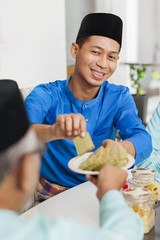 Wall Mural - Muslim man holding traditional Malay layer cake