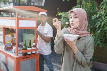 bakso. indonesian famous meatball street food. asian woman enjoy eating bakso