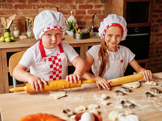 Children enjoying cooking in the kitchen. Boy and Girl at the kitchen. Family housekeeping