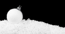 White Christmas Ball In The Snow On A Black White Background